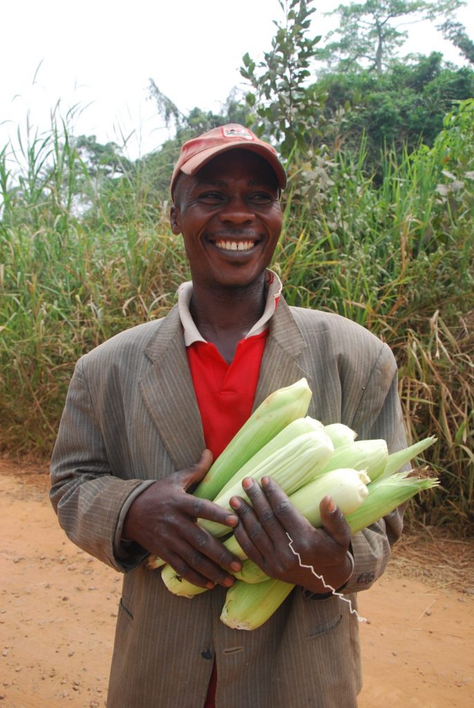 A farmer holds some corn on the cob
